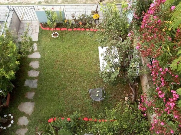 A garden with a lawn, stepping stones, and various plants and flowers. - Cosy Holiday Home in Preveza With Garden (Preveza)