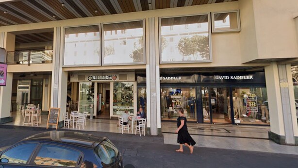 Un immeuble abritant un café appelé « Caffettam » et un magasin de vêtements appelé « David Saddler ».