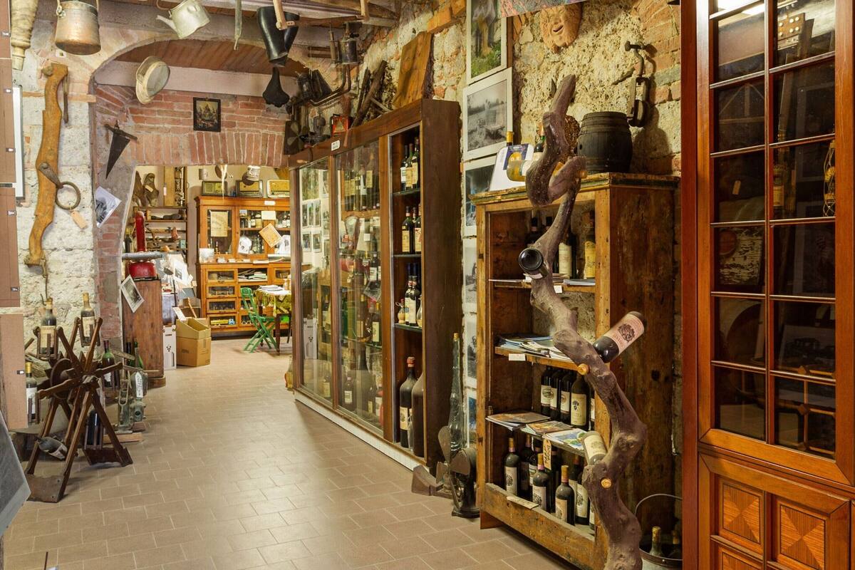 Un couloir étroit à la décoration rustique, avec des étagères en bois et des objets anciens.