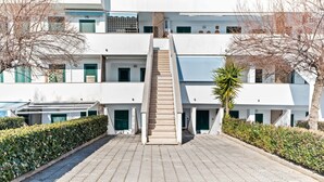 A modern multi-story building with a central staircase leading to the upper floors. - Apartment in Policastro Bussentino With Terrace (Santa Marina)