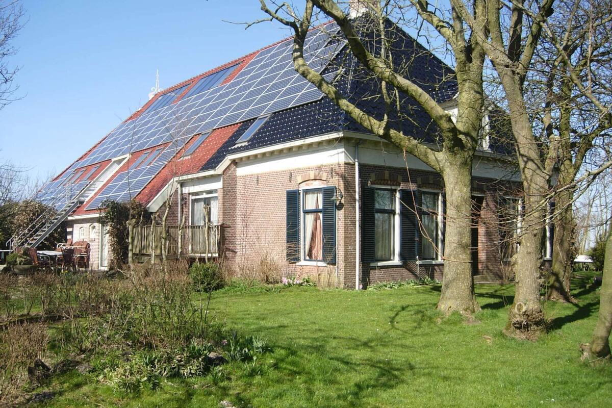 A house with a sloped roof, solar panels, and a brick exterior.