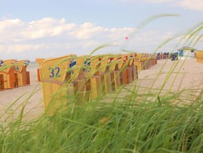 Beach huts line the shoreline, each with a simple, functional design for a relaxing beach stay.