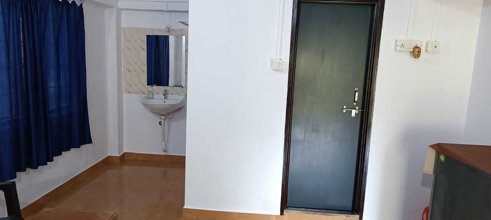 A bathroom with a sink, mirror, and blue curtains.