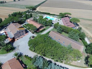 Une vue aérienne d’un quartier résidentiel avec de nombreuses maisons, une piscine et des champs environnants.