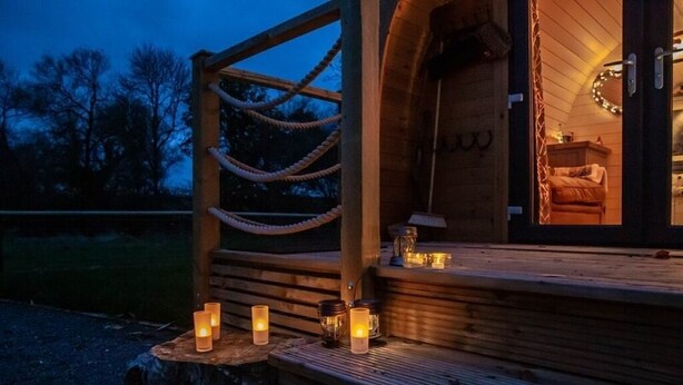 A wooden cabin with a cozy interior, a wooden deck with candles, and a rope ladder. - Rutland Rural Retreats - Woodpecker pod
 (Esher)