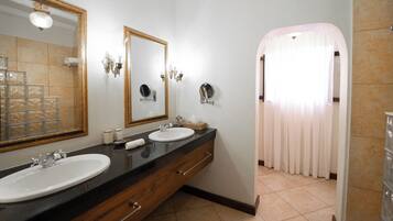 Un baño con dos lavamanos, un espejo grande y un mueble de tocador con cajones.