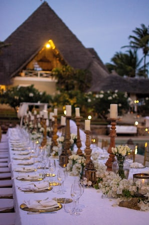 A table set for a formal dinner with candles, glasses, and flowers. - Lion in the Sun Boutique Hotel & Spa (Malindi)