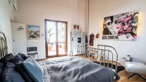 Ein Schlafzimmer mit einem Bett, einem Schreibtisch, einem Sessel, einem Heizkörper und einem Bild an der Wand.