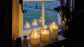Ein Fenster mit vier Fenstern, Kerzen an der Fensterbank und ein Salzstreuer.