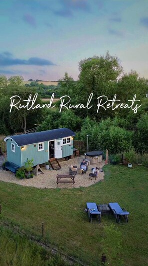 A rustic retreat with a small blue house, outdoor seating, and a hot tub. - Rutland Rural Retreats - Shepherds Rest
 (Belton In Rutland)