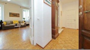 A living room with a sofa, coffee table, and a painting on the wall. - 4bnb - Corridoni Apartment (Rome)