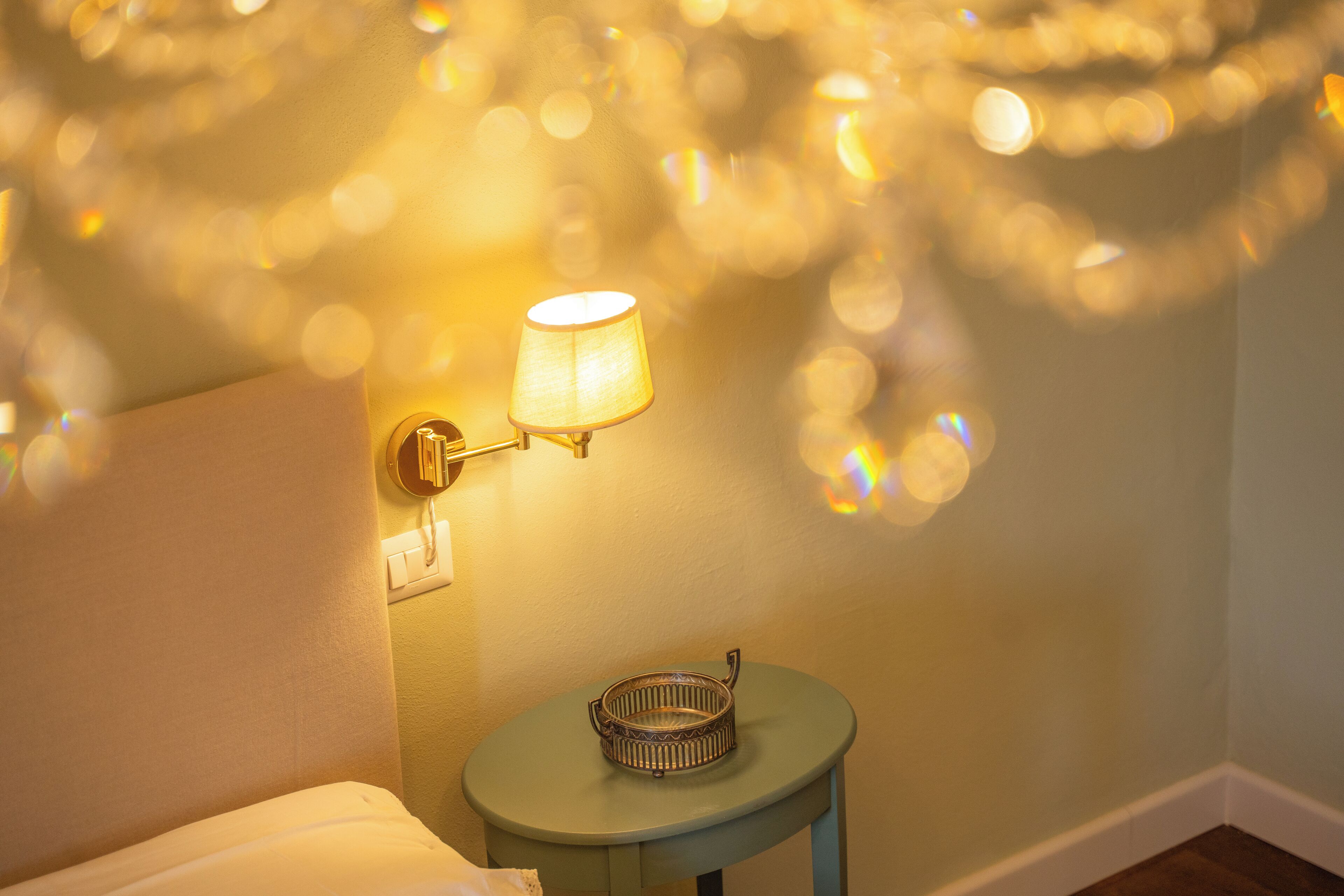 Une pièce comprenant un lit, une petite table avec une lampe et des guirlandes lumineuses décoratives accrochées au mur.
