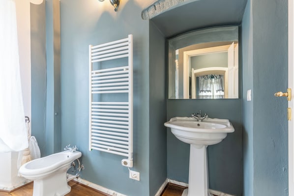 Une salle de bain avec un radiateur blanc, un lavabo et des toilettes.