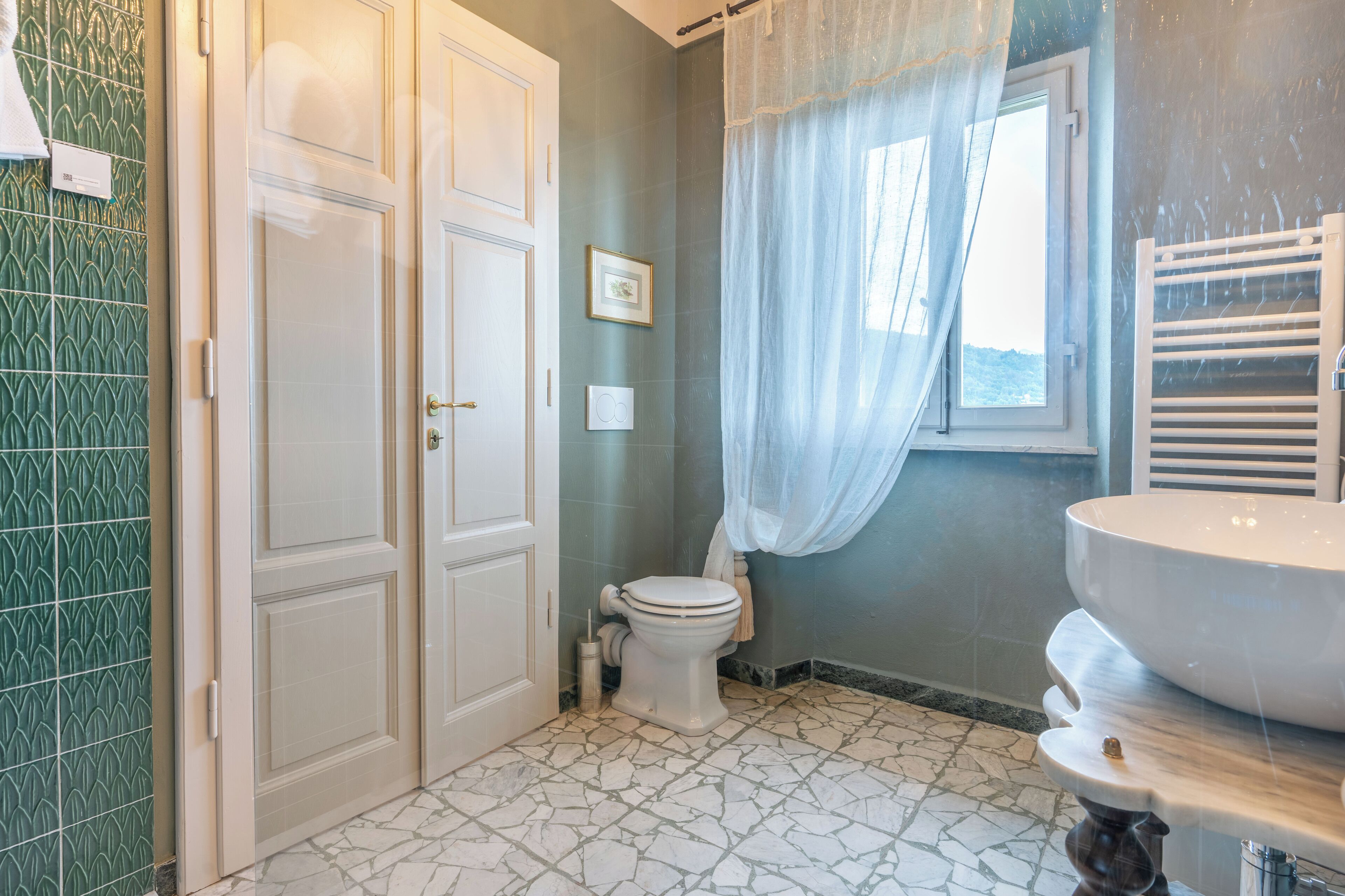 Un baño con inodoro, lavabo, cortina de ducha y ventana.