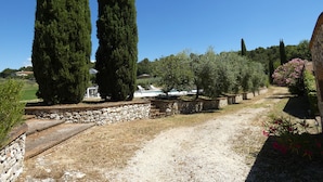 A gravel path leading to a pool area with stone walls and tall cypress trees. - SCAPPO IN UMBRIA, Casale Fasulo (Umbria)