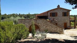 A stone house with a wooden bridge, surrounded by greenery and trees. - SCAPPO IN UMBRIA, Casale Fasulo (Umbria)