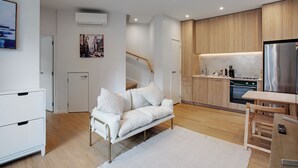 Une cuisine moderne avec des meubles en bois, un réfrigérateur en acier inoxydable et un four encastré.