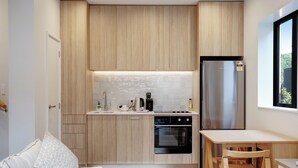 Une cuisine moderne avec des meubles en bois, un réfrigérateur en acier inoxydable et un four encastré.