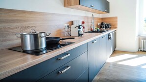 A modern kitchen with a wooden countertop, stainless steel cookware, and a coffee maker. - Le Domaine du Pavillon • The idyllic Brenne (Nuret-le-Ferron)