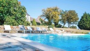 A swimming pool with lounge chairs and a stone border. - Le Domaine du Pavillon • The idyllic Brenne (Nuret-le-Ferron)