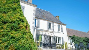 A two-story building with a balcony and outdoor seating. - Le Domaine du Pavillon • The idyllic Brenne (Nuret-le-Ferron)