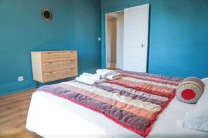A bedroom with a bed, a dresser, and a door.