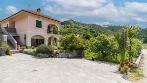 A pink villa with a stone patio, arched windows, and a staircase leading to the entrance. - Casa Melograno by Interhome (Sestri Levante)