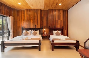 A double room with two wooden beds, a nightstand, and a window with curtains. - Tiny Home (Siem Reap)