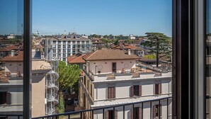 A cityscape with a mix of residential and commercial buildings, including a prominent white building with a red roof and a balcony. - Colonna Inn (Rome)