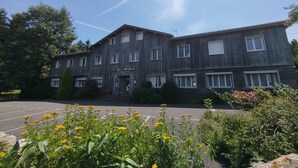 Ein zweistöckiges Gebäude mit der Aufschrift 'Le Bois Sauvage Restaurant & Hotel'.