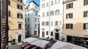 Une cour avec des places assises en plein air, un restaurant appelé « NODO » et un bâtiment portant l’enseigne « PIETRO MARIO ».