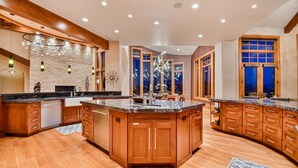 A spacious kitchen with wooden cabinets, granite countertops, and a central island.