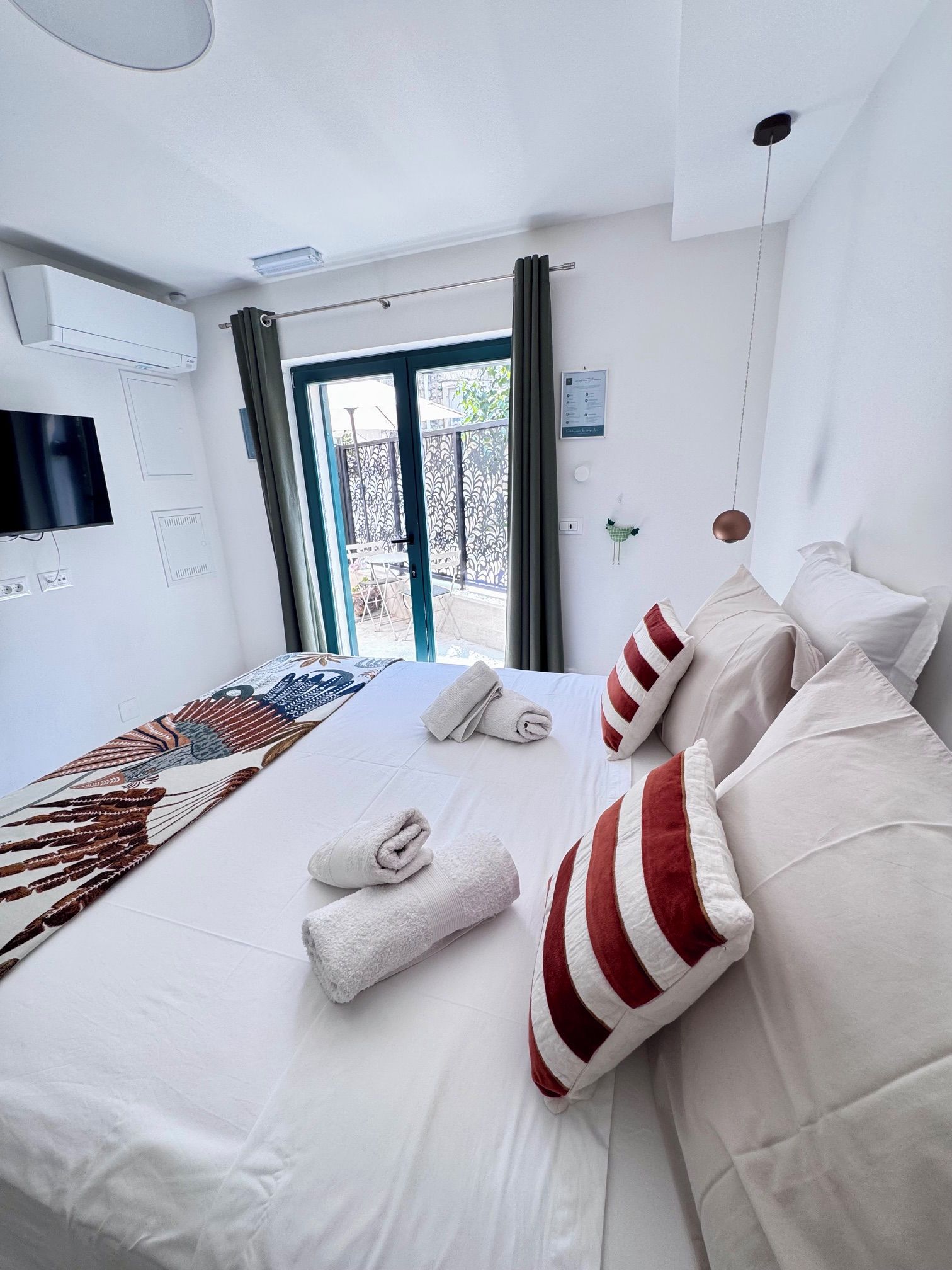Habitación de hotel con cama, televisión de pantalla plana, aire acondicionado y vistas al exterior.