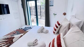 Habitación de hotel con cama, televisión de pantalla plana, aire acondicionado y vistas al exterior.