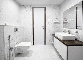 A modern bathroom with a toilet, shower, and sink.