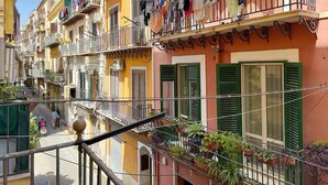 Una hilera de edificios coloridos con balcones, algunos con ropa tendida y macetas.