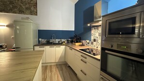 Eine moderne Küche mit Mikrowelle, Backofen und Spüle.