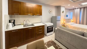A compact hotel room with a kitchenette, a bed, a sofa, and a small dining area. - Glamorous & Spacious Renovated Apartment, Syntagma (Athina)
