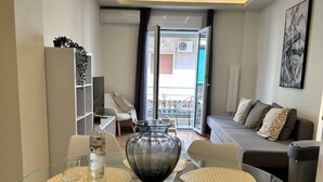 Ein moderner Essbereich mit einem Glastisch und Stühlen, einer dekorativen Schale als Mittelstück und Blick ins Freie.