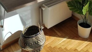 Un bagno moderno con un piano in legno, un lavandino bianco, uno specchio, un globo e una pianta in vaso.