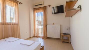 Una habitación con cama, radiador, televisor y una mesita.