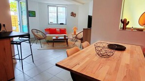 Ein modernes Wohnzimmer mit einem Holzesstisch, einer Couch und einem Fernseher.