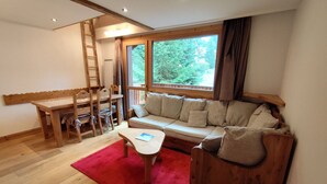 Une pièce chaleureuse avec un banc en bois, un canapé et une table.