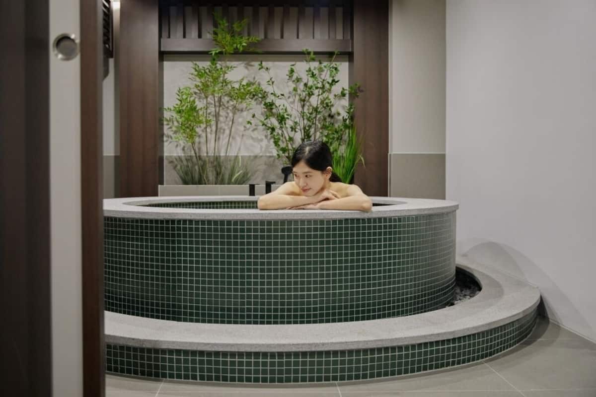 A spa area with a circular hot tub and a view of indoor plants.