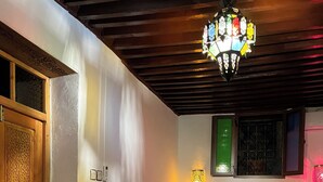 Ein Schlafzimmer mit einem Bett, einem Nachttisch, einer Wandlampe, einem Blumentopf und einer Zierdoor.