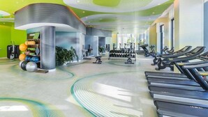 Un gimnasio con cintas de correr, pesas y pelotas de ejercicio.