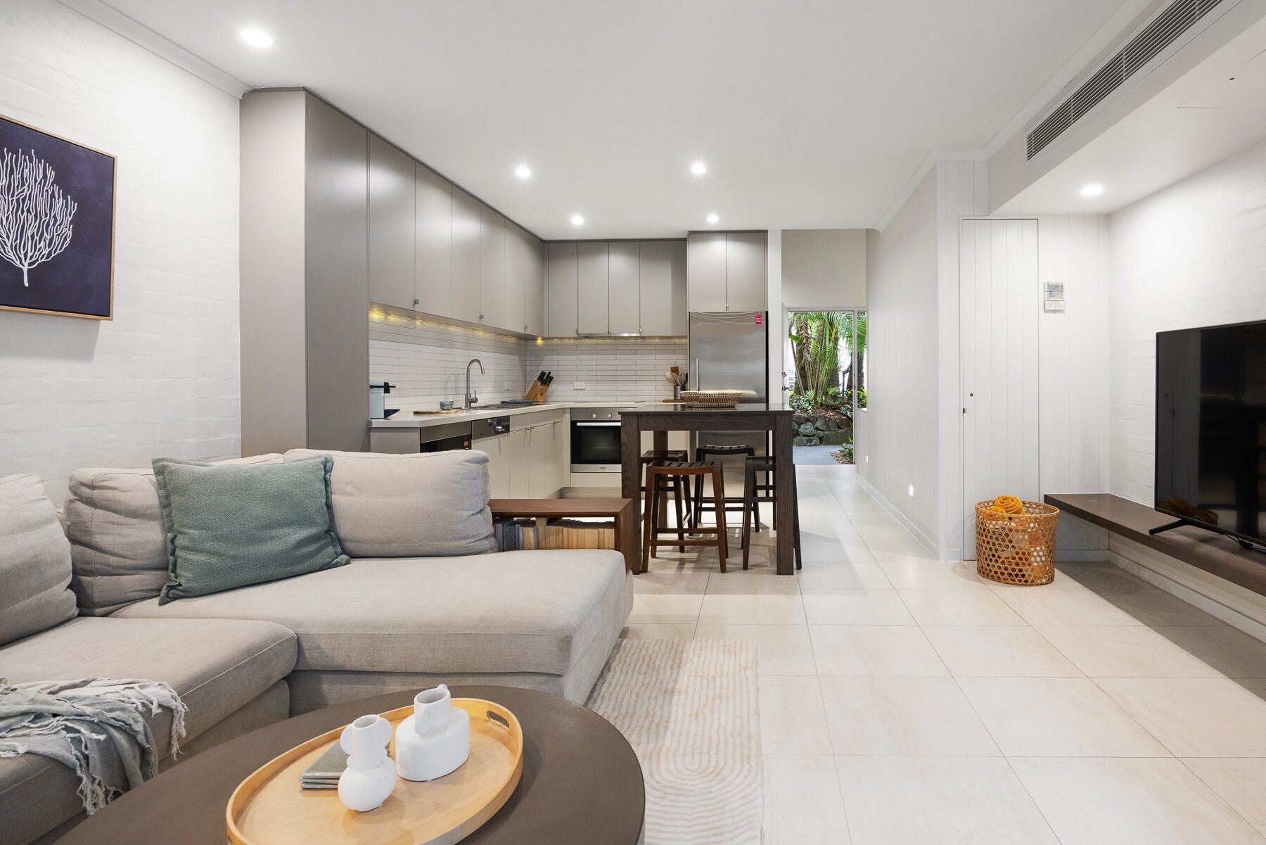 A modern living room with a sofa, a coffee table, and a TV.