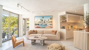 A modern living room with a sofa, coffee table, and a painting of a beach scene. - Little Cove Luxe - Naousa 10 (Noosa)