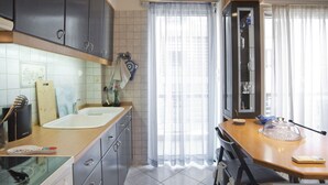 Una cucina moderna con un lavello grande, un piano di lavoro in legno e pensili scuri.
