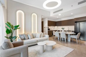 Una sala de estar moderna con sofá, mesa de centro y comedor con sillas y mesa.